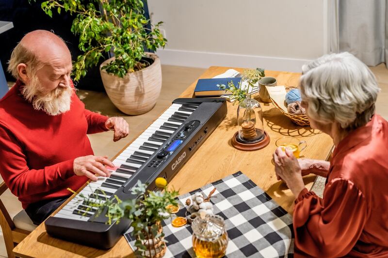 A care home resident who has dementia plays on a keyboard. PA