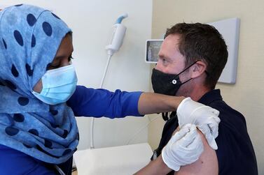 The National's Nick Webster receives a flu jab from nurse Resy Hussain at Prime Hospital in Dubai. Medics urged the public to get vaccinated this winter, which may help to prevent confusion between flu and Covid-19 symptoms. Pawan Singh / The National