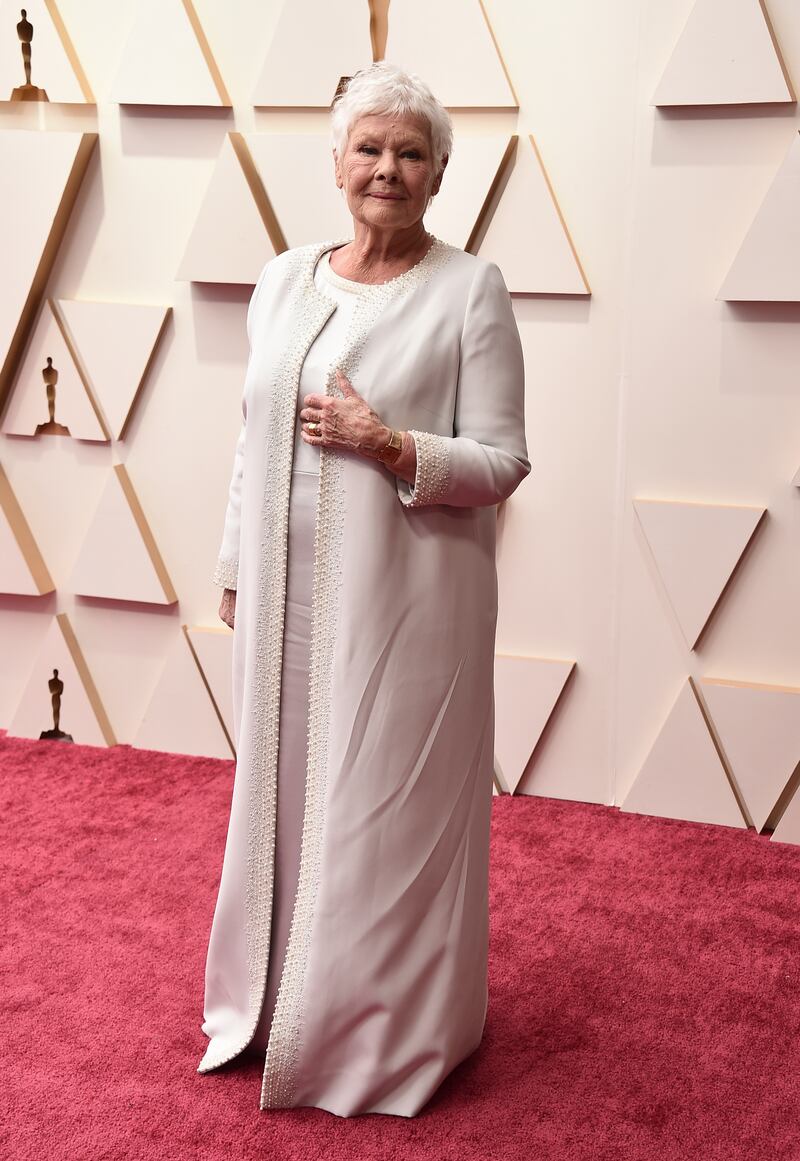 Judi Dench, wearing an ivory dress and dress coat. AP