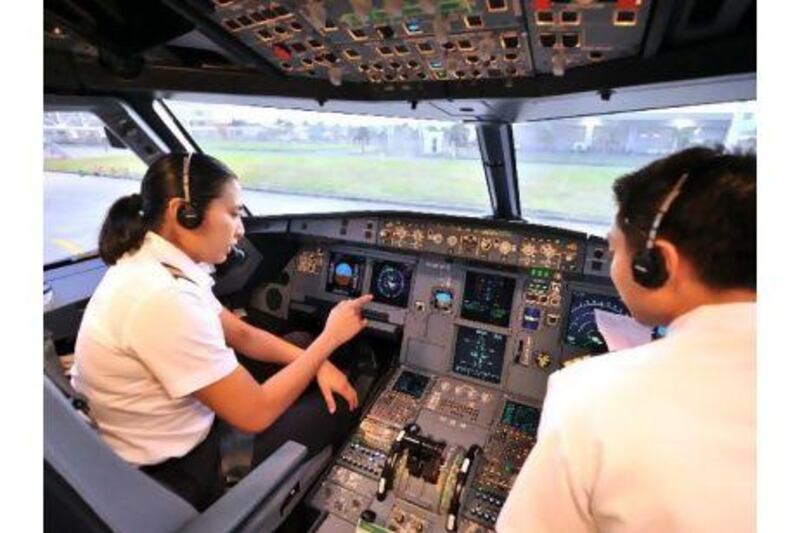 Pilot Brooke Castillo, left, gives instructions to her first officer before a flight from Iloilo international airport in the Philippines to Manila. Ms Castillo is the Philippines' first female commercial jet captain.