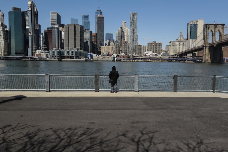 A person stands at Brooklyn Bridge Park in the Brooklyn Borough of New York, U.S., on Wednesday, April 15, 2020. New York City may lose a half-million jobs and run about $10 billion short on tax revenue through mid-2021 because of the coronavirus outbreak, the city's Independent Budget Office estimated. Photographer: Stephanie Keith/Bloomberg