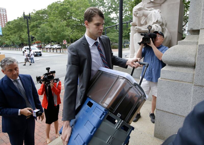 Mr Carman carries documents as he arrives at the federal courthouse. AP