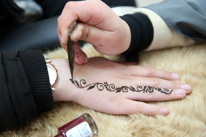 Palestinian henna tattoo artist Samah Sidr draws an intricate entwining tattoo on a girl's hand at an event to celebrate International Women's Day, in the West Bank city of Hebron. The global event seeks to help create a gender-equal world. EPA