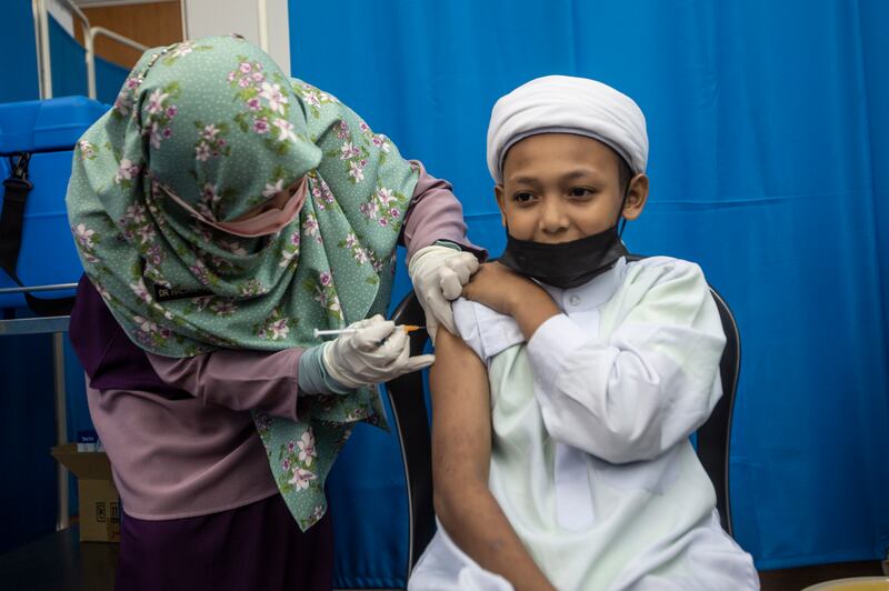 A young pupil receives a Covid-19 vaccination at Kelana Jaya Mediacal Centre in Kuala Lumpur. Photo: EPA
