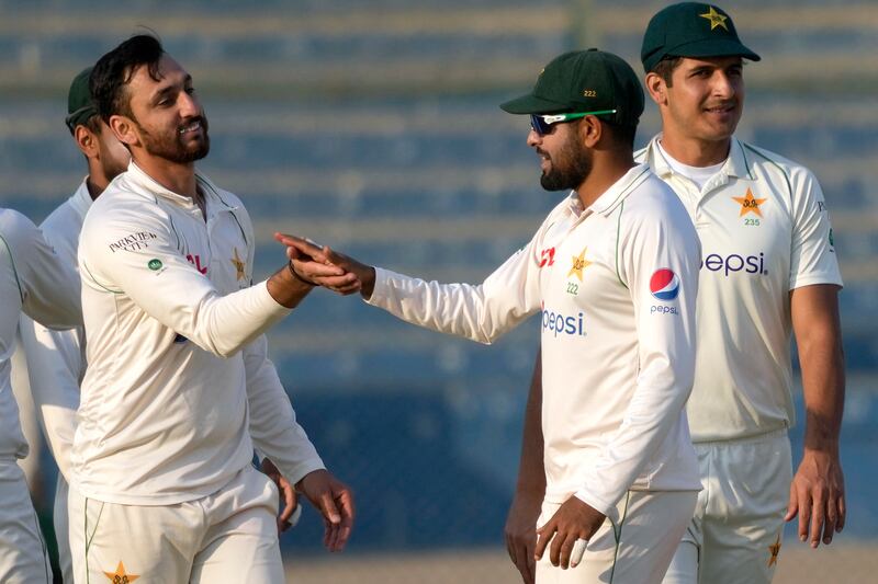 Pakistan's Agha Salman, left, celebrates with Babar Azam after the dismissal of New Zealand's Henry Nicholls during the first day of the second Test in Karachi on Monday, January 2, 2023. AP