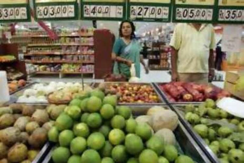 Indian shoppers gesture as they buy vegetable and fruit at a Mall in Kolkata on June 27, 2008.  India's annual rate of inflation has risen to 11.42 percent on the back of rising prices of food, fuel and manufactured goods, government data released on on June 27, 2008 showed.   AFP PHOTO/Deshakalyan CHOWDHURY
