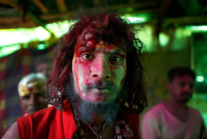 A devotee's face is smeared with ash and colors at a cremation ground on the banks of river Ganges at the Manikarnika Ghat in Varanasi, India, Friday, March 6, 2020. Thousands of Hindus celebrate their major festival Holi with ash collected from pyres in a cremation ground, following an age-old tradition. Hindu mythology says deity Shiva, known as "The Destroyer," visited cremation grounds to play Holi with ghosts who couldn't celebrate the festival of colours. As per their tradition, Hindus burn the bodies of their dead in pyres of dry woods. AP