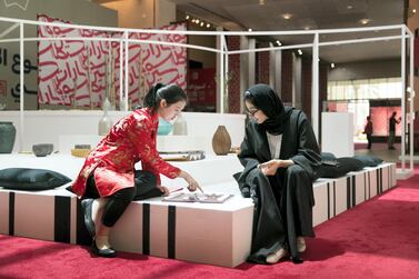 An Emirati woman and a Chinese woman play xiangqi or Chinese chess, at Manarat Al Saadiyat in Abu Dhabi. Reem Mohammed / The National