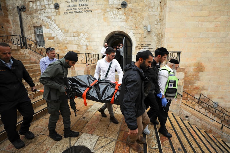 Israeli security personnel carry a dead body down the steps following the shooting. Reuters