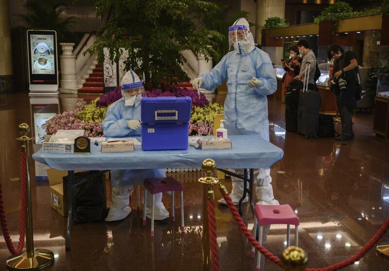 A Chinese health worker prepares to carry out a nucleic acid test on a journalist entering a hotel to spend a night in isolation before attending the opening of the National People's Congress in Beijing, China. Getty Images