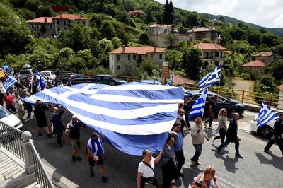 Protesters carry a giant Greek national flag during a demonstration against the agreement reached by Greece and Macedonia to resolve a dispute over the former Yugoslav republic's name, in Pisoderi village, northern Greece, June 17, 2018. REUTERS/Alexandros Avramidis