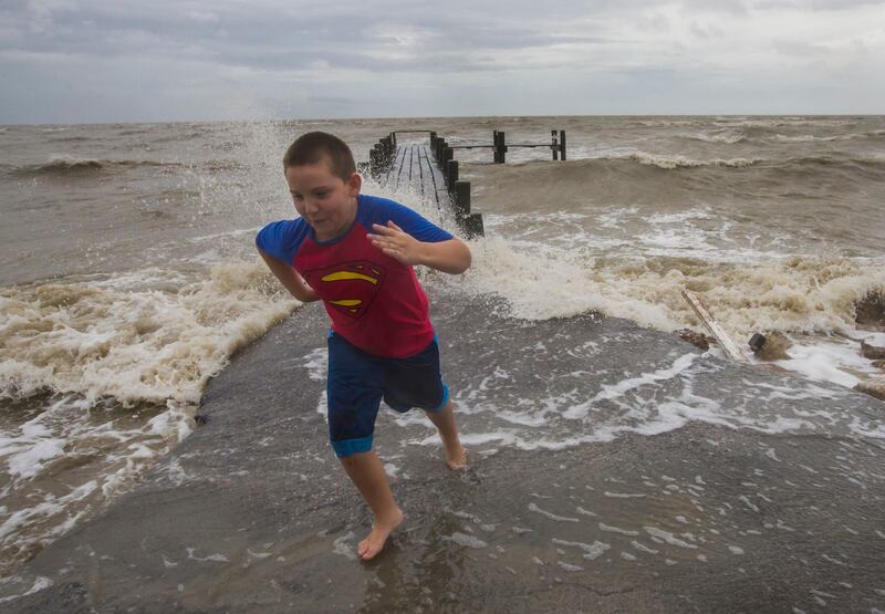 Bobby Starnes, 11, plays near a pier in Bacliff, Texas, as Hurricane Harvey approaches the Texas coast. Stuart Villanueva / The Galveston County Daily News via AP