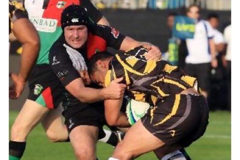 Abu Dhabi's Alastair Common, left, tackles a Dubai Wasps player at Emirates Palace.