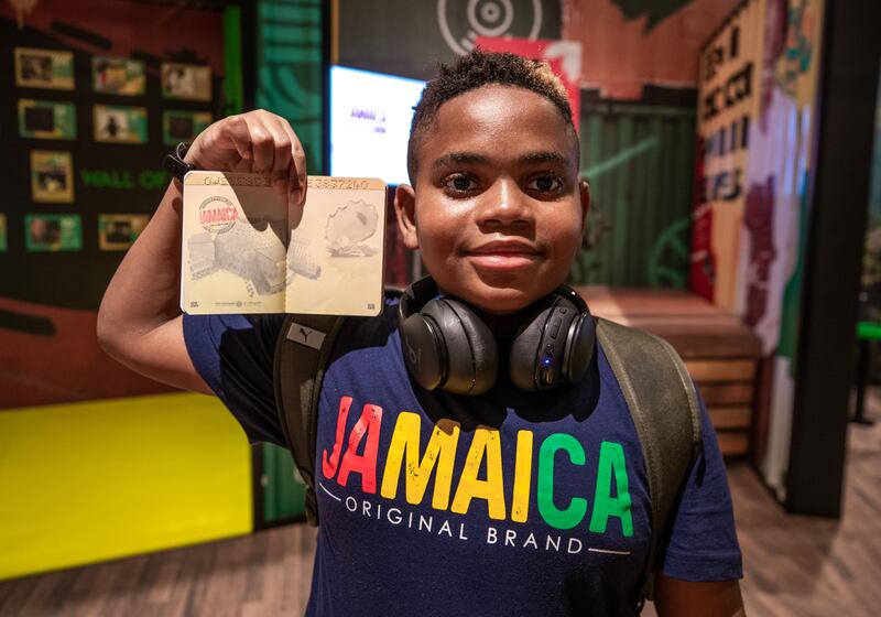 Jhaequan Stewart shows the stamp he collected at the Jamaica pavilion. Victor Besa / The National