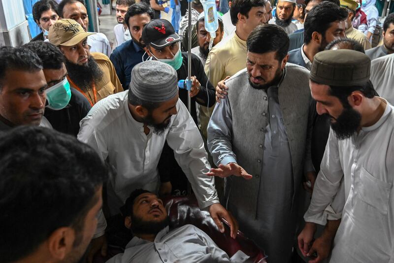 Haji Ghulam Ali, second from right, Governor of Khyber Pakhtunkhwa province, greets an injured man in a hospital in Peshawar.  AFP