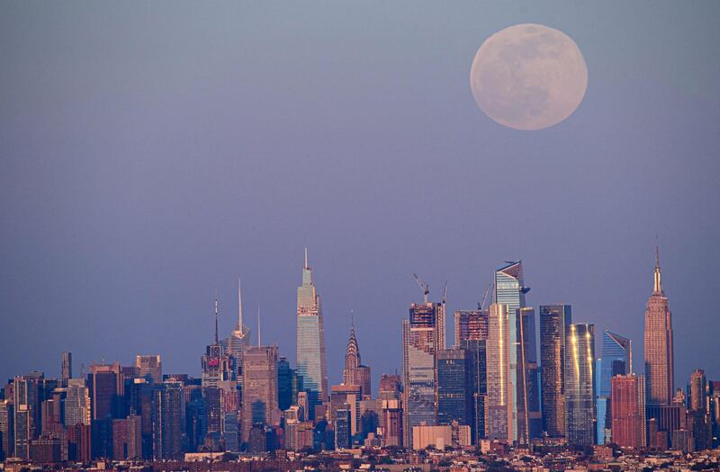 The full moon of April, called the Super Pink Moon, rises over the skyline of Manhattan on April 26, 2021.  / AFP / Angela Weiss
