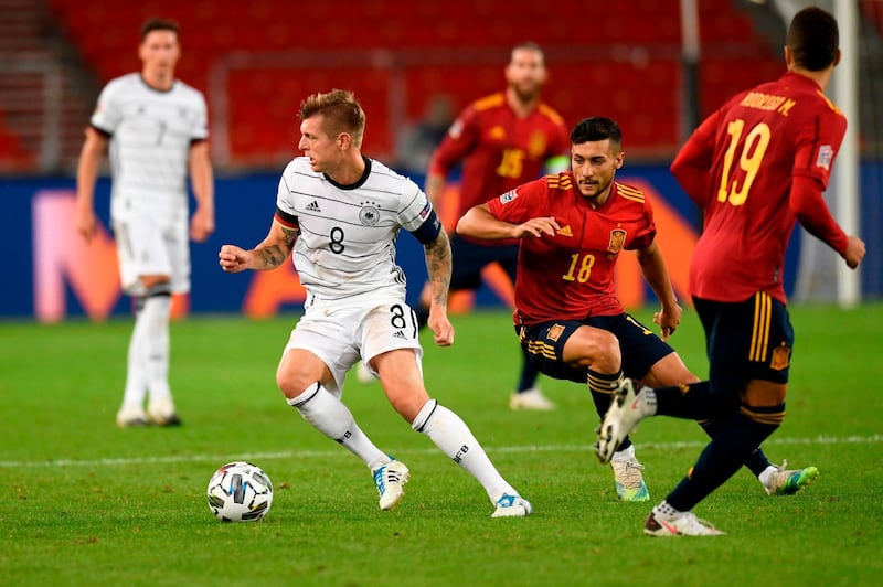 Germany midfielder Toni Kroos shrugs off a challenge from Spain midfielder Oscar Rodriguez. AFP