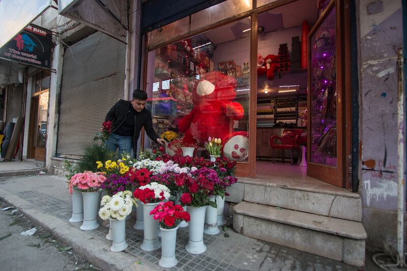 Ahmed arranges flowers in front of his shop.