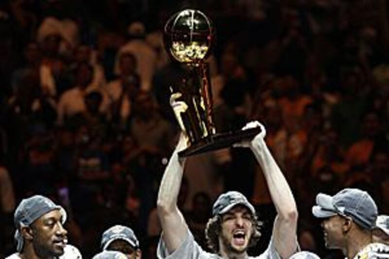 Pau Gascol, the LA Lakers' Spanish forward, lifts the NBA Championship trophy after his team clinched the finals with a 99=86 win over the Orlando Magic.