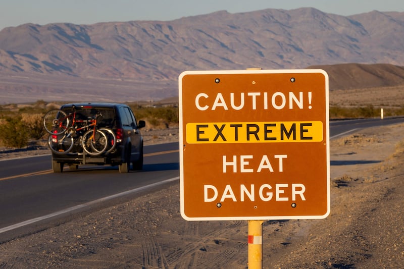 A car passes a sign warning of extreme heat in Death Valley National Park, California. AFP