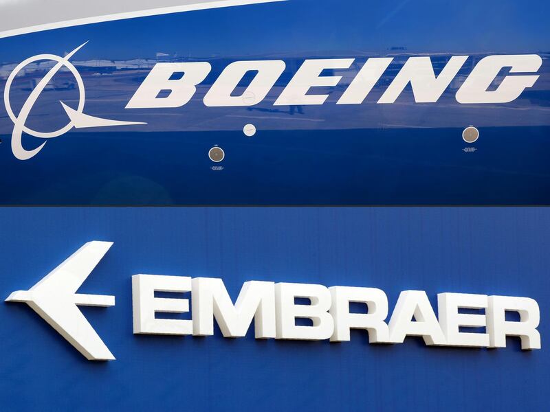 (FILES) This combination of file pictures created on December 21, 2017 shows the Boeing logo on the fuselage of a Boeing 787-10 Dreamliner test plane presented on the tarmac of Le Bourget airport near Paris on June 18, 2017, and the logo of Brazil's aircraft manufacturer Embraer also taken at Le Bourget airport, on June 23, 2013. The EU said on October 4, 2019, it has opened an "in-depth investigation" into plans by US aviation giant Boeing to form joint ventures with the world's number three planemaker, Brazil's Embraer, citing competition concerns.
 / AFP / ERIC PIERMONT
