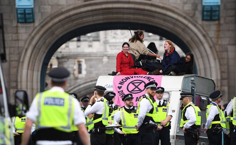 Police officers stand near Extinction Rebellion environmental movement protesters demonstrating on Tower Bridge. EPA