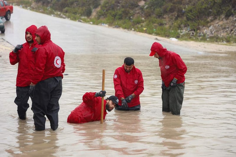 Members of the Libyan Red Crescent work on opening roads engulfed in floods at an undefined location in eastern Libya. AFP
