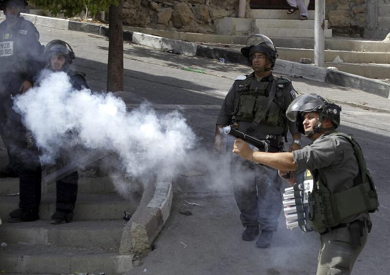 Israeli border police shoot tear gas towards Palestinian protesters during clashes following the killing of an Israeli couple, in the West Bank city of Hebron, last week. Abed Al Hhashlamoun / EPA