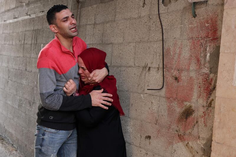 A Palestinian man and woman cry on May 16, 2021 outside their destroyed home in Gaza City, following nearly a week of Israeli air strikes on the Gaza Strip and the Hamas movement firing rocket barrages into Israel.  / AFP / MOHAMMED ABED
