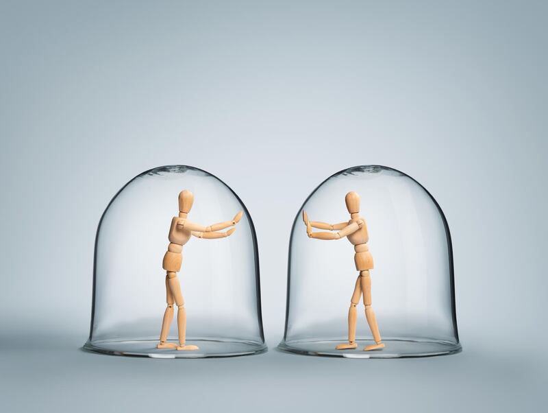 Human puppets each in it's own glass bubble expressing love while being apart from each other