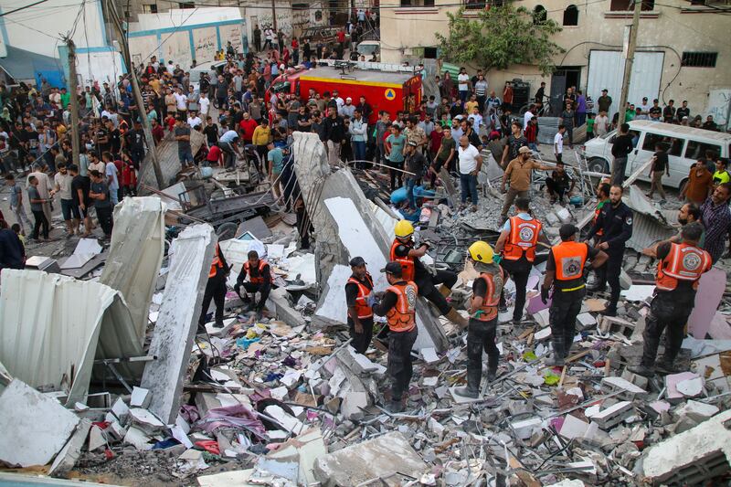 Rescuers search for victims and survivors in buildings destroyed by air strikes in Khan Younis, Gaza. Getty