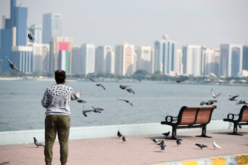 Families feed pigeons during the 51st National Day long weekend in Abu Dhabi. Khushnum Bhandari / The National
