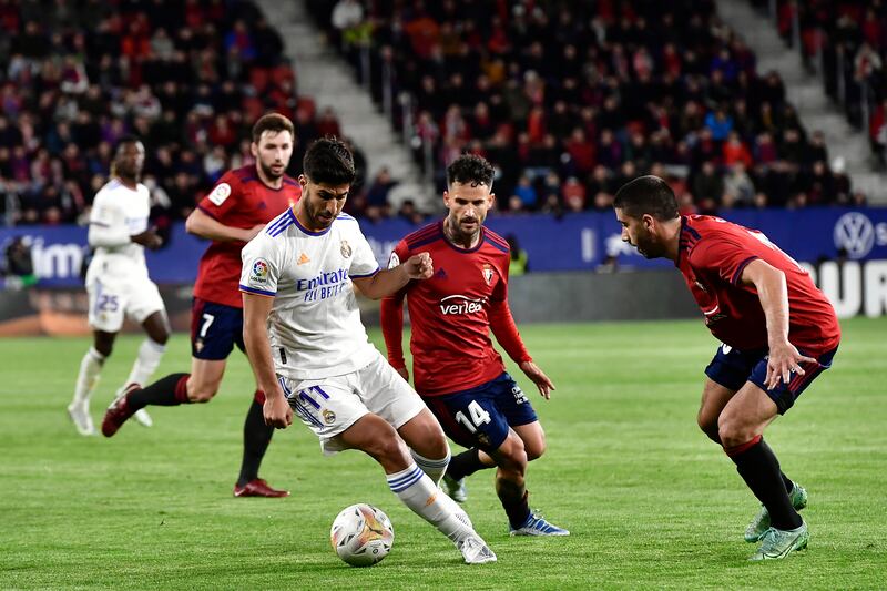 Real Madrid's Marco Asensio on the ball under pressure from Osasuna players. AP