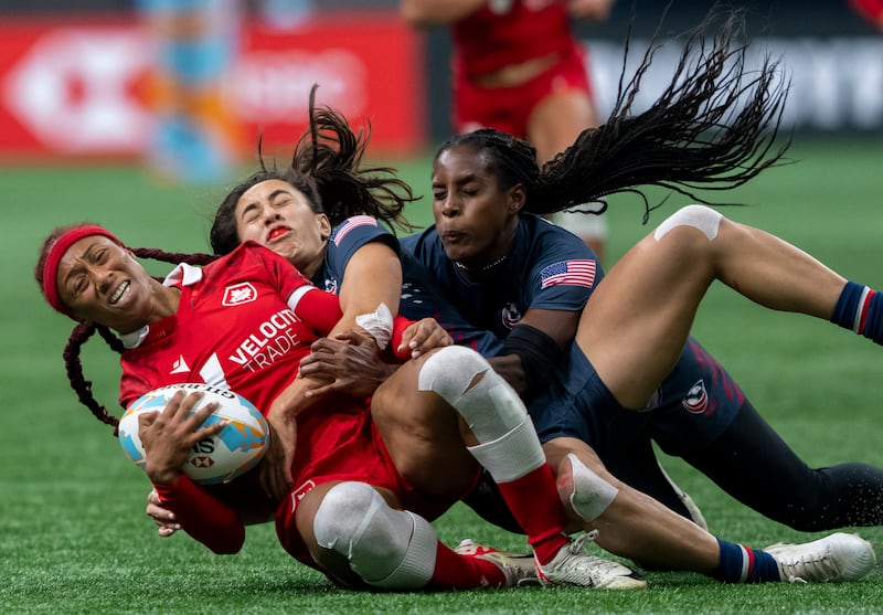 Canada's Charity Williams (left) is tackled by Alex Sedrick (centre) and Naya Tapper of the US during a women's rugby match, in Vancouver. AP