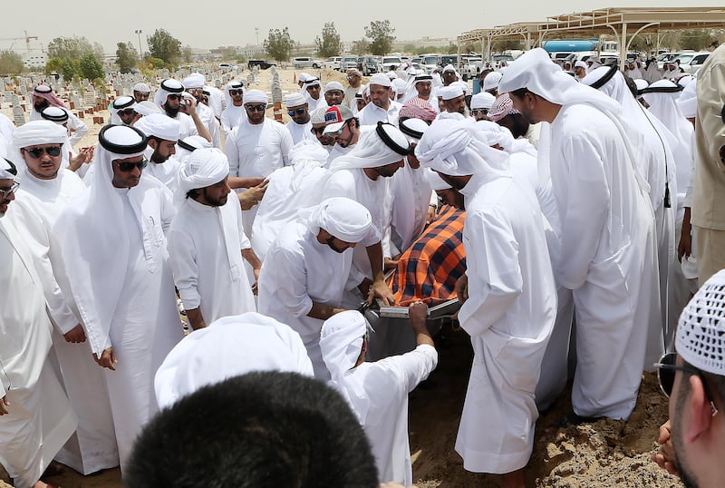 Friends and family members attend the burial of Khaled Qai at the Al Qusais Cemetery in Dubai. Pawan Singh / The National 