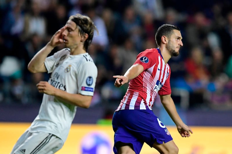 Real's Luka Modric, left, reacts as Atletico's Koke celebrates after scoring his team's fourth goal. AFP