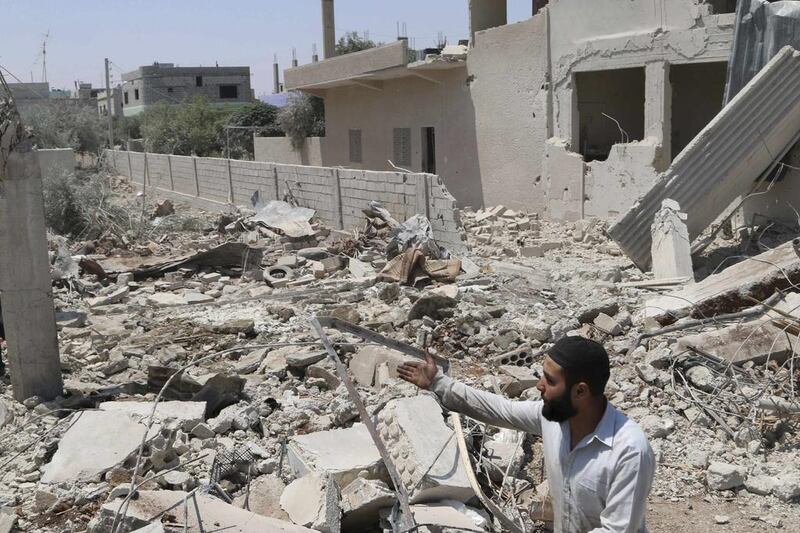 A man inspects a site hit by what activists say was a barrel bomb dropped by forces loyal to President Bashar Al Assad in Saida village in the eastern countryside of Deraa province on May 11, 2014. Mohamed Fares / Reuters