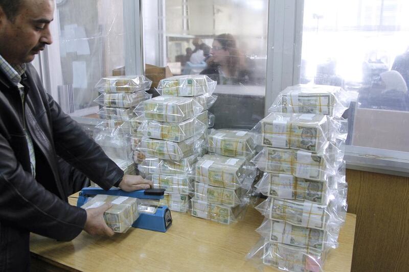 An employee seals bags of Syrian pound notes at the Syrian central bank in Damascus. Khaled al-Hariri / Reuters
