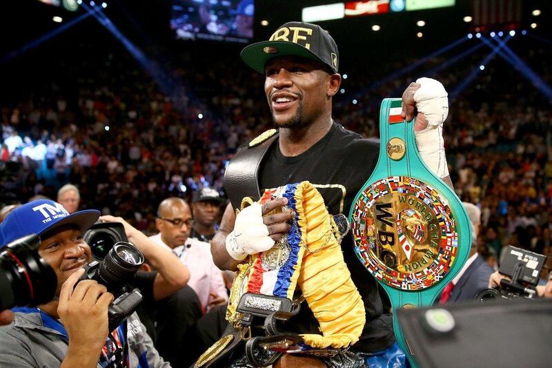 Mayweather celebrates his majority decision victory – extending his unbeaten professional record to 45 fights. Al Bello / Getty Images / AFP
