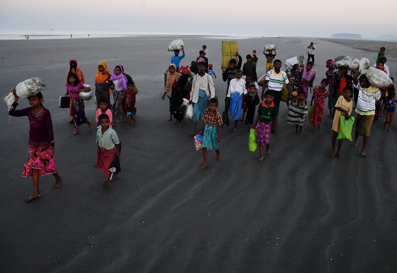 (FILES) In this file picture taken on November 9, 2017 Rohingya Muslim refugees who entered Bangladesh by boat walk towards refugee camps after landing at the Saplapur beach in the Teknaf district. When hundreds of thousands of Rohingya fled Myanmar into Bangladesh two years ago, local communities were mostly welcoming. Today that welcome has worn thin, and resentment, anger and fear are creeping in.
 - XGTY / To go with story 'BANGLADESH-MYANMAR-REFUGEE-ROHINGYA-UNREST', FOCUS by Sam Jahan
 / AFP / Dibyangshu SARKAR / XGTY / To go with story 'BANGLADESH-MYANMAR-REFUGEE-ROHINGYA-UNREST', FOCUS by Sam Jahan
