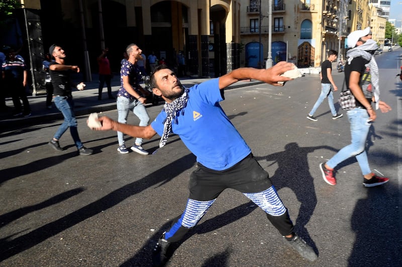 Protesters throw stones during demonstrations against power cuts and the high cost of living, outside the Lebanese Parliament, in downtown Beirut. EPA