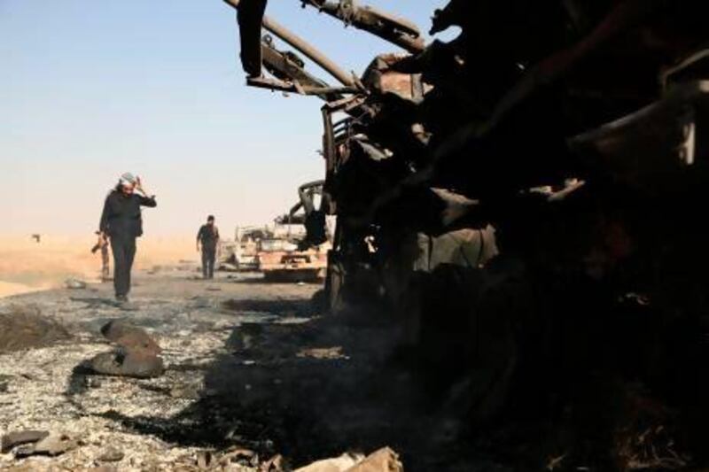 Syrian rebels inspect what's left of a government convoy following clashes in the outskirts of the northern city of Raqqa.