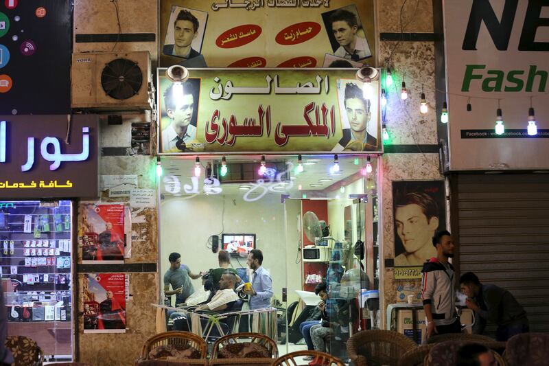 Syrians work at a barber in an area called 6 October City in Giza, Egypt. Reuters