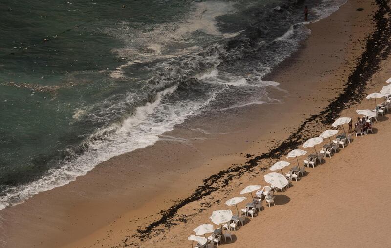 In this Aug. 8, 2019, photo, garbage creeps towards the shore at Stanley Beach in Alexandria, Egypt. Authorities say that 11 people drowned off the coast of northern Egypt on Friday, July 10, 2020 at a beach known for its rocky jetty and fast-moving waters. (AP Photo/Maya Alleruzzo, file)