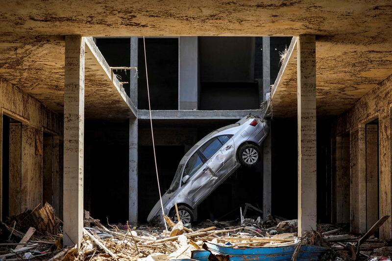A tilted car sits above debris in Libya's eastern city of Derna. AFP