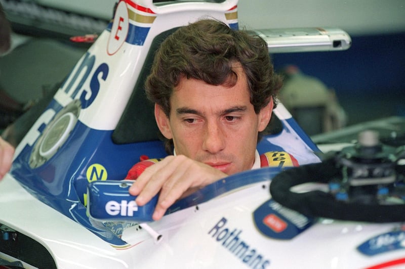 (FILES) In this file picture taken on May 1, 1994 Brazilian F1 driver Ayrton Senna adjusts his rear view mirror in the pits before the start of the San Marino Grand Prix in Imola, Italy. May 1, 2019 marks the 25th anniversary of Ayrton Senna's death during the San Marino Grand Prix, raced at the Imola circuit in Italy. / AFP / JEAN-LOUP GAUTREAU
