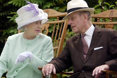 (FILES) In this file photo taken on July 17, 2002 Britain's Queen Elizabeth II (L) and Britain's Prince Philip, Duke of Edinburgh (R) chat while seated during a musical performance in the Abbey Gardens, Bury St Edmunds, during her Golden Jubilee visit to Suffolk, east of England. Prince Philip, the 98-year-old husband of Queen Elizabeth II, went into hospital on Friday, December 20, 2019 for precautionary treatment on a pre-existing condition, Buckingham Palace said. / AFP / Fiona HANSON
