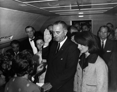 Lyndon B. Johnson taking the oath of office aboard Air Force One at Love Field Airport two hours and eight minutes after the assassination of John F. Kennedy, Dallas, Texas. Jackie Kennedy (right), still in her blood-soaked clothes, looks on. November 22, 1963. Executive Office of the President of the United States