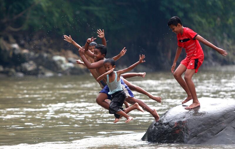 Indonesian children play on a rock as they swim in the Ciliwung River in Bogor, Indonesia. Based on a report issued by the Directorate General of Pollution Control and Environmental Degradation of the Ministry of Environment and Forestry (KLHK), in 2015 the majority of rivers in 33 Indonesian provinces had a water quality status of severely polluted.  Adi Weda / EPA