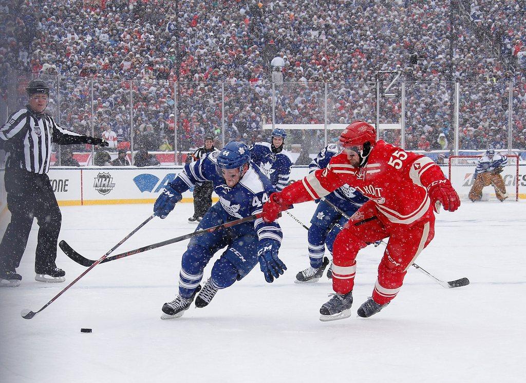 Morgan Rielly #44 of the Toronto Maple Leafs and Niklas Kronwall #55 of the Detroit Red Wings battle for the puck in the first period during the NHL Winter Classic at Michigan Stadium on Wednesday in Ann Arbor, Michigan. Gregory Shamus/Getty Images